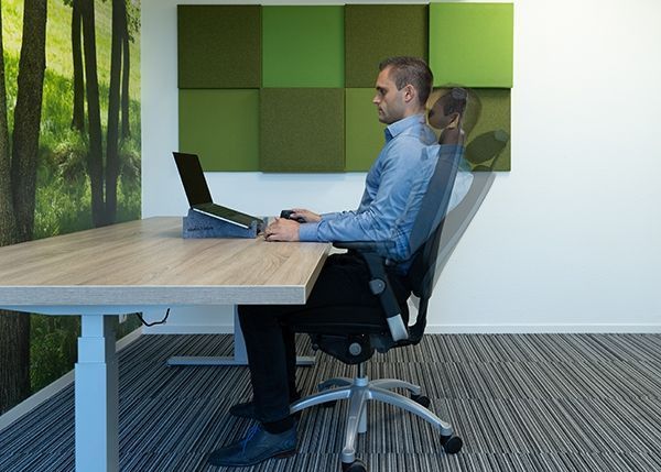 Persoon in een werkomgeving op een ergonomische bureaustoel