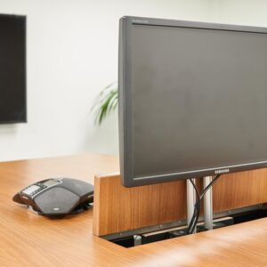 Detail van ingebouwde monitor en ergonomische muis op houten tafel – technologische integratie in moderne projectinrichting.